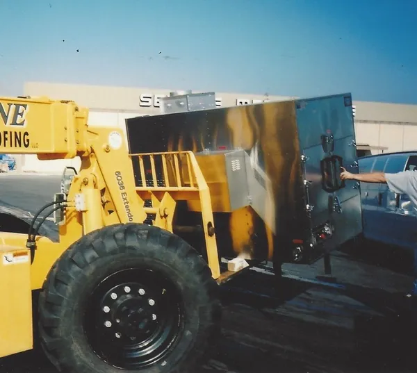Lifting a smoker off a trailer with a telehandler