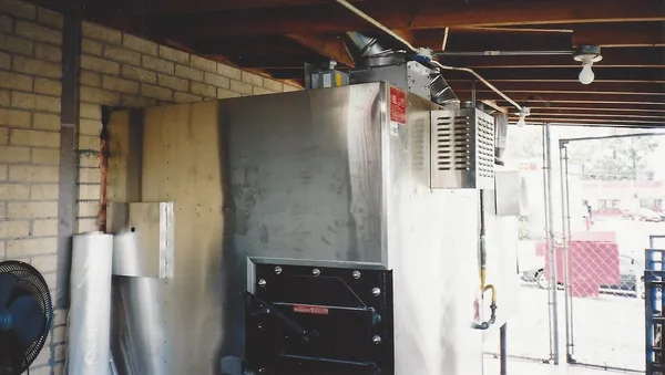 An installed smoker and its flue inside a building