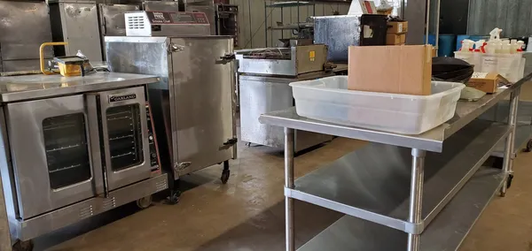 Used restaurant equipment 2: commercial convection oven beside a stainless steel prep table