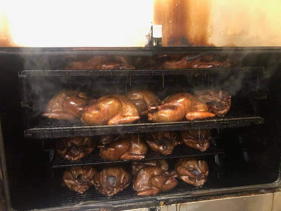 large amounts of food being cooked on smoker 